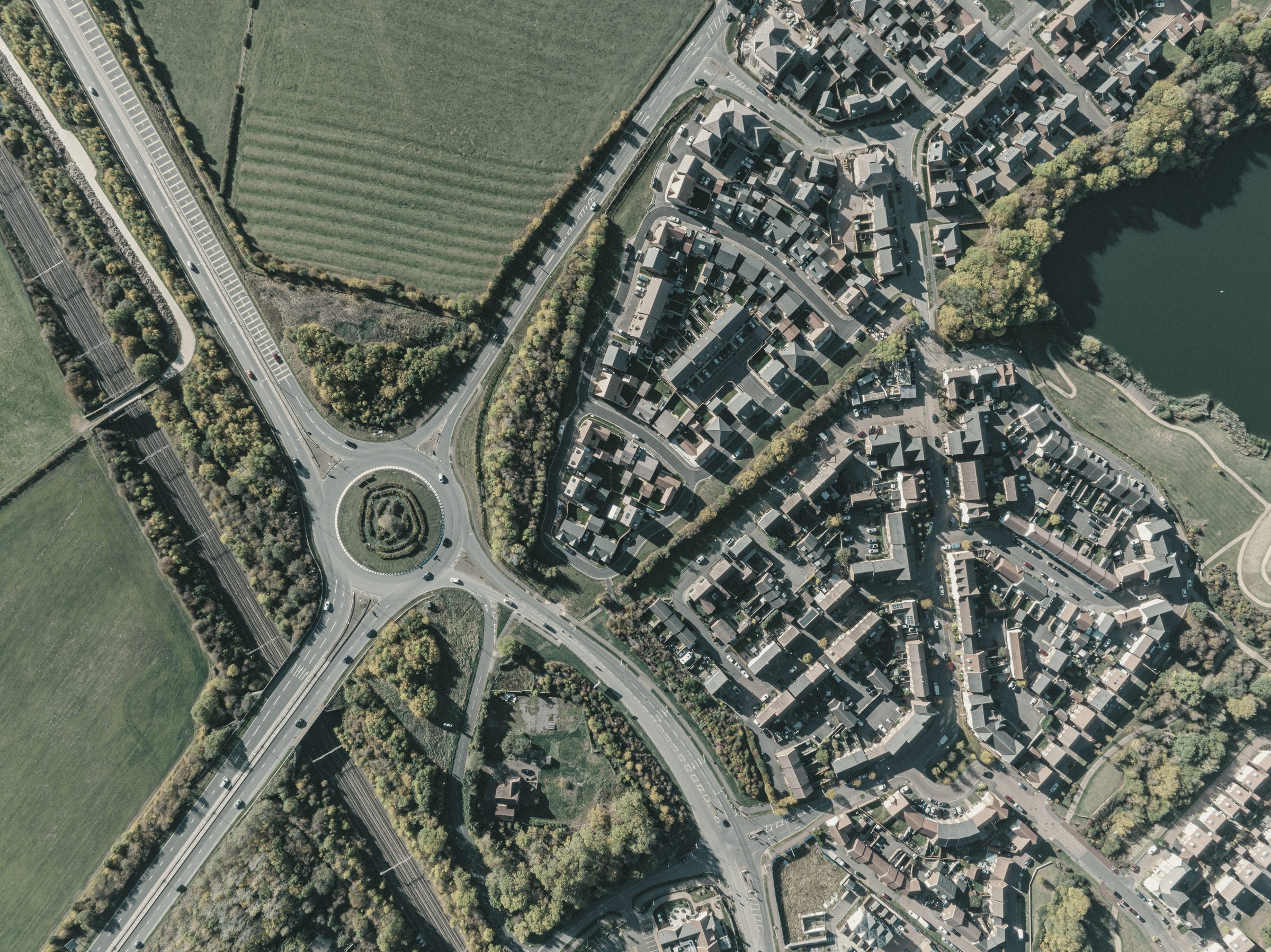 Aerial view of English countryside, with farmland and hedgerows meeting the edge of a town